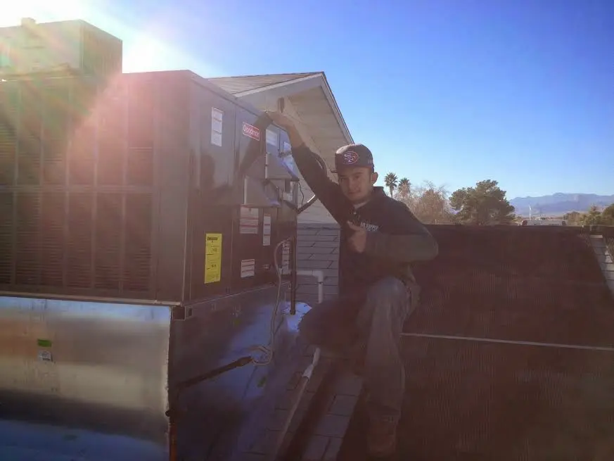 HVAC technician performing Air Duct Cleaning on a rooftop unit in Ingleside